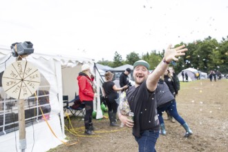 A festival visitor throws confetti on a tent site at the Rock am Ring festival on Saturday,