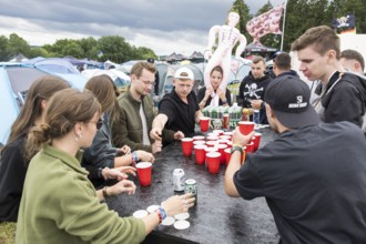 Festival visitors play a drinking game on a campsite at the Rock am Ring Festival on Saturday,