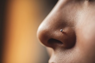 Close-up of delicate silver nose stud on female skin in warm light. Generative ai, AI generated