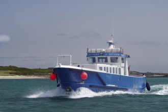 Large blue boat in motion on wavy sea with red buoy, passenger ferry, Isles of Scilly, Cornwall,