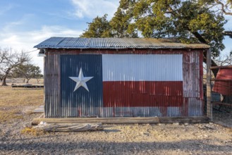 Texas state flag painted on a storage shed building on a private ranch in Sonora, Texas, USA