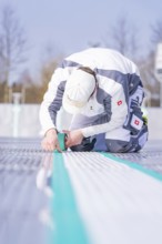 Close-up of a worker applying adhesive tape with a concentrated look on his face, renewing the