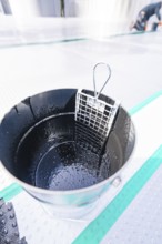 Close-up of a wet metal bucket with grid insert, shiny and detailed, renewal of the swimming lines,