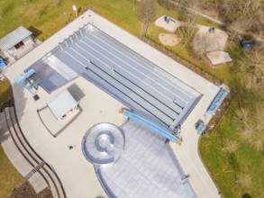 Close-up aerial view focussing on the long swimming pool and vegetation, renovation of the swimming