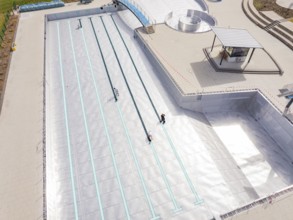 High-angle shot of an empty swimming pool under construction with metal walls, renewal of the