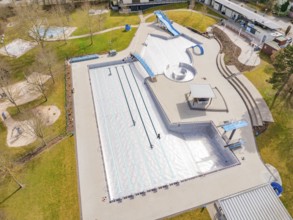 Wide aerial view of the swimming pool with various leisure structures and lawn, renovation of the