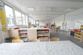 Spacious kindergarten with shelving and table groups for activities, transitional containerised