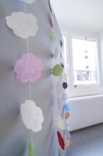 Colourful paper cloud decoration hangs near a window, transitional daycare centre in container