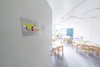 Bright classroom view through an open door with the sign 'Spessart', transitional daycare centre in