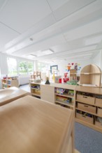 Versatile and bright room with furniture, shelves and toys, transitional daycare centre in