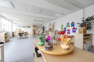Art area with neatly arranged coloured pencils on a table, transitional daycare centre in container