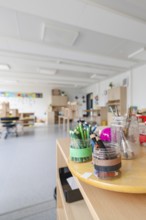 Close-up of art tools and pencils on a table in a sunny room, transitional daycare centre in