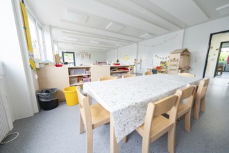 Inviting table area in the kindergarten with decorations and toys, transitional containerised
