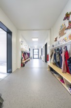 Bright corridor in a kindergarten full of children's clothes and colourful decorations,