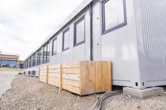 Side view of a modular building with timber panelling and windows, transitional daycare centre in