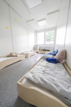 Light-flooded dormitory with low beds and pillows under the stars, transitional daycare centre in