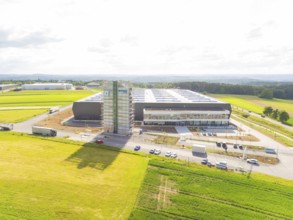 Bird's eye view of a modern industrial building surrounded by green fields, ING Park development