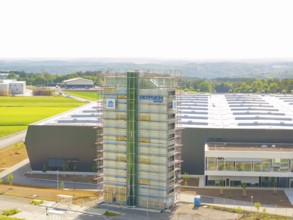Front view of an industrial building with scaffolding and fields in the background, ING Park