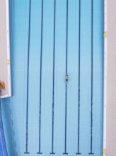 A single swimmer swims in an empty blue pool, Calw outdoor pool, Black Forest, Germany