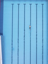 A single swimmer in an empty pool, the water is calm and clear, Calw outdoor pool, Black Forest,