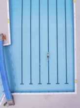 A swimmer in an empty swimming pool, bird's eye view, Calw outdoor pool, Black Forest, Germany