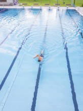 A person swims alone in an almost empty pool along the lanes, Calw outdoor pool, Black Forest,