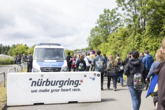 Festival visitors walk past a barrier on their way to the main entrance at the Rock am Ring