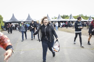 A festival visitor runs after passing the main entrance at the Rock am Ring Festival on Friday,