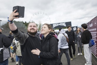 Festival visitors Kevin and Jenny take a photo in front of a container with the Rock am Ring logo