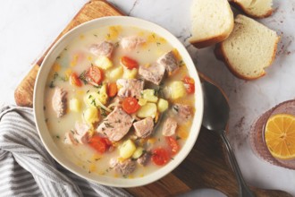 A bowl of soup on a light background, Finnish fish soup, lohikeito soup, creamy fish soup