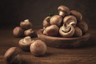 Brown champignons, royal mushrooms, in a wooden bowl, on a wooden table
