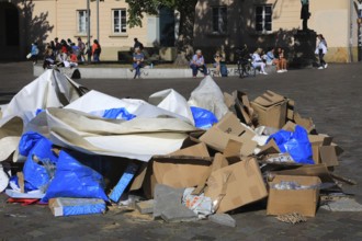 A pile of waste paper and cardboard on the street, remnants of an event, trash, trash, here in