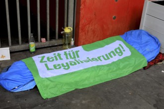 Sleeping bag and overnight place of a homeless person, on it a foil with the inscription Time for