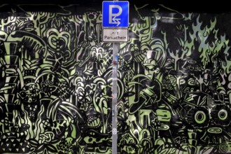 Parking sign in front of a graphite wall