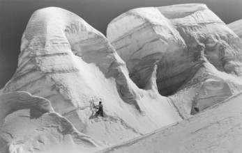 Winter, mountaineer with ice axe climbing in snow and ice, mountaineering in the Alps,