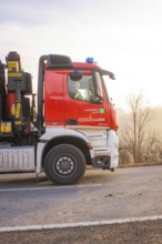 Red fire engine on a country road at sunset, fire brigade exercise on the Hermann Hesse Railway,