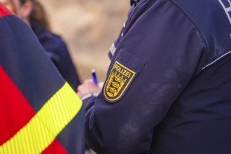 Close-up of a police uniform badge. Writing and coat of arms are visible, fire brigade exercise at