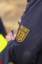 Close-up of a police badge on a blue uniform with lettering and logo, fire department exercise at