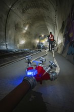 A water tap and fire hose in the foreground of a tunnel, fire brigade exercise on the Hermann Hesse