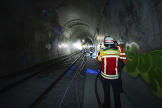 Firefighters work with hoses in a tunnel with graffiti, fire department exercise on the Hermann