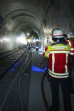 Deployment of firefighters in a tunnel with hoses and equipment, fire brigade exercise on the
