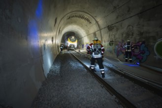 Firefighters working in an illuminated tunnel with graffiti, fire brigade exercise on the Hermann