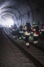 Firefighters in a tunnel focusing on darkness and equipment, fire department exercise on the