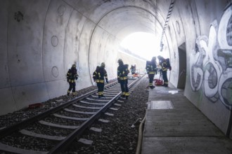 Firefighters working in a graffiti-covered tunnel, fire brigade exercise on the Hermann Hesse