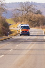 An ambulance drives along an empty country road, fire department exercise on the Hermann Hesse
