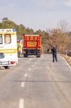 Emergency vehicles and personnel in action on a country road in winter, fire department exercise on