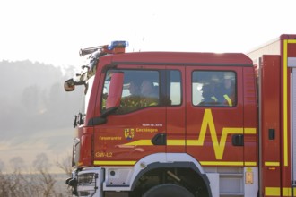 Closer look at a fire engine driving on a street with people inside, fire department exercise on