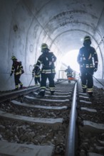 Firefighters on train tracks in a tunnel during an operation, fire brigade exercise on the Hermann
