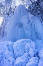 Urach waterfall full of bizarre ice formations frozen at winter temperatures, Bad Urach, Swabian