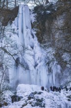 Spectators marvel at the Urach waterfall full of bizarre ice formations, frozen at low winter